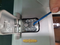 Unlocking the adjusting screw on a uPVC door hinge