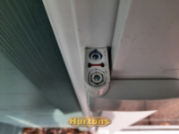 Adjusting the height screw on a uPVC door hinge