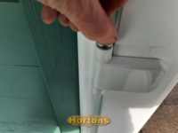 Exposing the height adjustor on a uPVC door hinge
